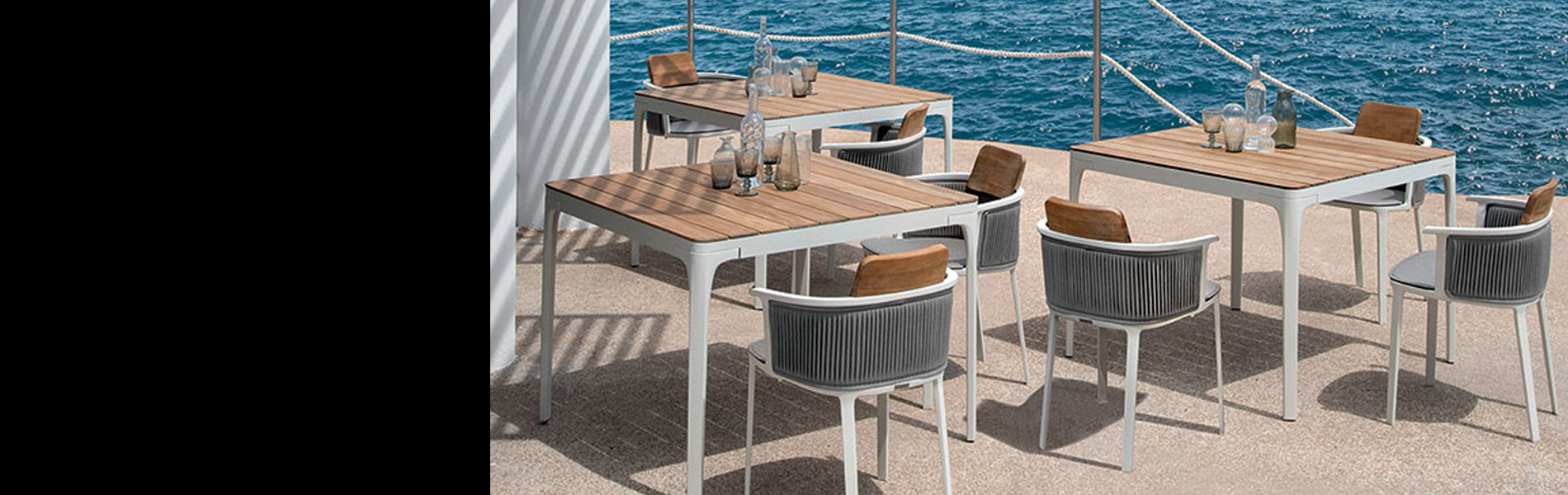 港の見えるウッドデッキに配置されたラグジュアリーなガーデンセット