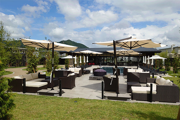 リゾートホテルのプールサイドに設置された大型パラソル（AWAUMI 富士河口湖リゾート施工例）